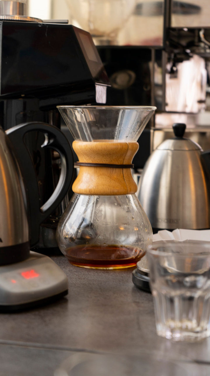 Chemex posée sur un plan de travail pendant l'infusion du café.