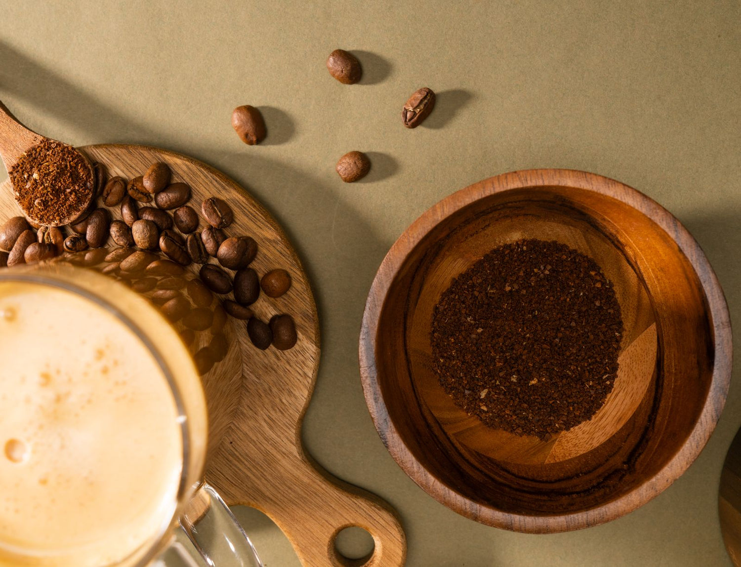 Vue du dessus de grains de café, café moulu et tasse sur une planche en bois.